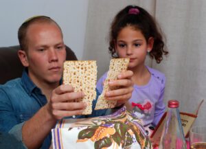 Jewish family eating Matzah at the Passover Seder (Shutterstosck)